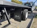 A 2018 Ford F-750 flatbed truck with visible rear tire and branded side panel showcasing the logo of Abante Motor Group