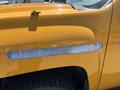 A yellow 2013 Chevrolet Silverado 1500 with a partially sanded area on the side showing exposed metal under the paint