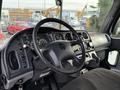 Interior view of a 2015 Freightliner M2 with a black steering wheel dashboard controls and gauges