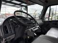 Interior view of a 2021 Freightliner M2 106 featuring a steering wheel dashboard controls and a gray seat