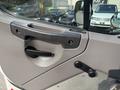 The interior door handle of a 2010 Freightliner M2 106 featuring a textured grip and a rotary knob for window control