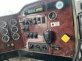 Close-up of the dashboard of a 2003 International 5600i featuring gauges switches and controls for various functions