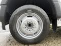 Close-up of a silver wheel from a 2018 Ford F-550 featuring visible lug nuts and a black tire with tread pattern