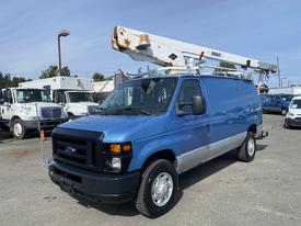 A blue 2009 Ford Econoline van with a raised utility boom positioned on the roof and tools attached to the exterior