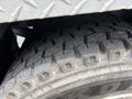 Close-up of a worn tire on a 2013 Kenworth T370 showcasing deep treads and rugged texture