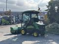 A 2021 John Deere 1575 lawn mower with a cabin and a front-mounted mower deck in green and yellow colors