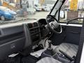 Interior view of a 2009 Suzuki Carry showing the dashboard gear shift and seating area with gray fabric upholstery