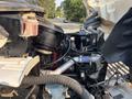 Close-up of the engine compartment of a 2016 Freightliner M2 106 showcasing various engine components and hoses