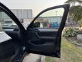 A 2013 BMW X3 with an open driver's side door showcasing the interior features and dashboard
