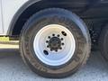 Close-up of a white tire mounted on a vehicle with the brand name Goodyear visible and five bolts securing it to the rim