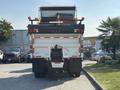 A 2013 International WorkStar truck with a large open bed and multiple lights on the top and rear, designed for hauling and construction purposes