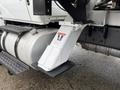 A white 2020 International MV607 truck with a metal support bracket and a warning label on the side near fuel tanks and other mechanical components