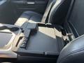Interior view of a 2018 RAM 3500 with a black leather seat and a console featuring a flat tray and cup holders