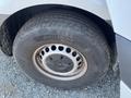 Close-up of a wheel on a 2022 Mercedes-Benz Sprinter showing a silver rim and a textured tire with a visible tread pattern