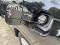 A 2014 Honda CR-V fuel door is open revealing the fuel cap secured by a string