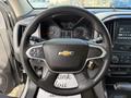 A close-up of the steering wheel of a 2018 Chevrolet Colorado featuring the Chevrolet logo and various control buttons