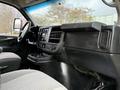 Interior view of a 2015 GMC Savana showing the dashboard steering wheel and front seats with a focus on the console and controls