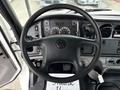 The interior of a 2021 Freightliner M2 106 featuring a steering wheel with dashboard controls and instrumentation panel in front of the driver