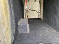A 2015 Ford F-550 interior with a metal compartment featuring a perforated design placed on a dark carpeted surface