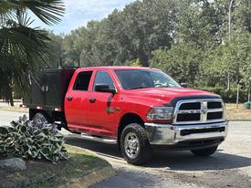 A red 2013 RAM 2500 pickup truck with a black utility bed parked on a driveway