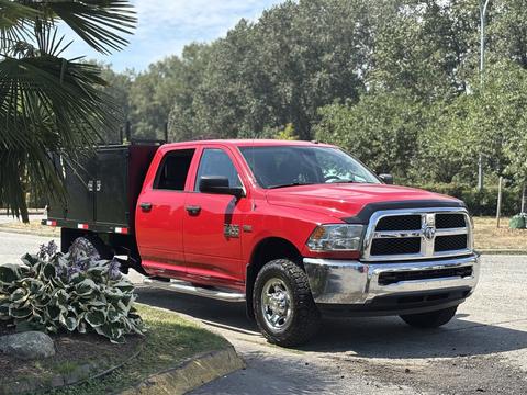 A red 2013 RAM 2500 pickup truck with a black utility bed parked on a driveway