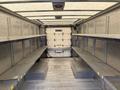 Interior of a 2012 Ford Econoline cargo van featuring metal shelving on both sides and a plain open space at the back