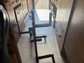 A metal frame with various attachments is positioned on the floor of a vehicle, demonstrating a utilitarian design for supporting equipment or tools
