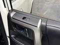 Interior door handle and control panel of a 2018 Toyota 4Runner showing the lock and unlock buttons