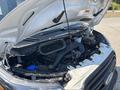 A 2019 Ford Transit 350 with its hood raised revealing the engine compartment showcasing various components and fluids visible inside the engine bay
