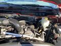 View of the engine compartment of a 2015 RAM 2500 showing the engine components including the alternator and coolant reservoir