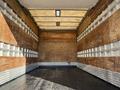 A 2010 Ford F-450 empty box truck with wooden panels and a black floor inside the cargo area