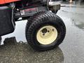 A close-up of a wheel from a 2012 Kubota F3680 featuring a black tire with a textured tread and a yellow rim