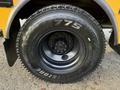 Close-up of a black tire mounted on a wheel featuring the brand name Bridgestone and the model M775