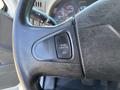 Close-up of a black steering wheel with a cruise control button labeled "CRUISE/THROTTLE OFF" on the left side