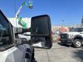 A 2011 Ford F-550 with a side mirror prominently displayed in the foreground