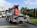 A 2010 International 4300 truck with a mounted crane on the back and a flatbed trailer with a textured surface