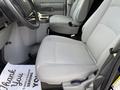Interior view of a 2011 Ford Econoline with grey fabric seats and a center console showing cup holders and a floor mat that reads Thank You