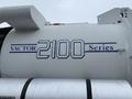 A close-up of a white truck's side showing the blue text "VACTOR 2100 Series" printed on the tank