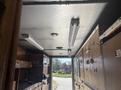 Interior of a 2008 Workhorse W62 showing wooden cabinetry and storage compartments with a ceiling light fixture and overhead lighting