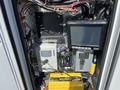A 2013 Chevrolet Express with electrical components including a monitor, a battery charger, and various wires and connectors in a metal compartment