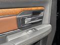 Close-up of the door handle and controls of a 2015 RAM 1500 featuring a wood trim and chrome accents