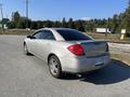A 2006 Pontiac G6 in silver color parked at an angle showcasing its rounded rear design and tinted windows