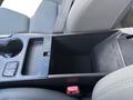A 2014 Hyundai Sonata center console showing an open storage compartment with cup holders and controls for the vehicle's features