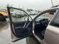 A 2016 Subaru Forester with an open driver's side door showing the interior features including the steering wheel and dashboard