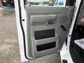 The image shows the open side door of a 2009 Ford Econoline with a gray interior panel featuring a handle and storage compartments