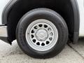 A close-up of a white 2022 GMC Sierra 1500 wheel with a silver rim and a General Grabber tire displaying its tread pattern