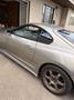 A 1997 Toyota Supra with a sleek silver body and sporty bronze aftermarket wheels showcasing its iconic curves and design features