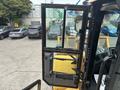 A 2012 Caterpillar 980 front loader with an open door showcasing the interior controls and seat