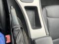 Close-up of the center console of a 2011 BMW 3-Series featuring a gear shift lever and a storage compartment with textured surface