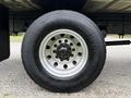 The image shows a close-up of a 2018 Freightliner M2 106 wheel featuring a black tire mounted on a silver rim with several lug nuts visible